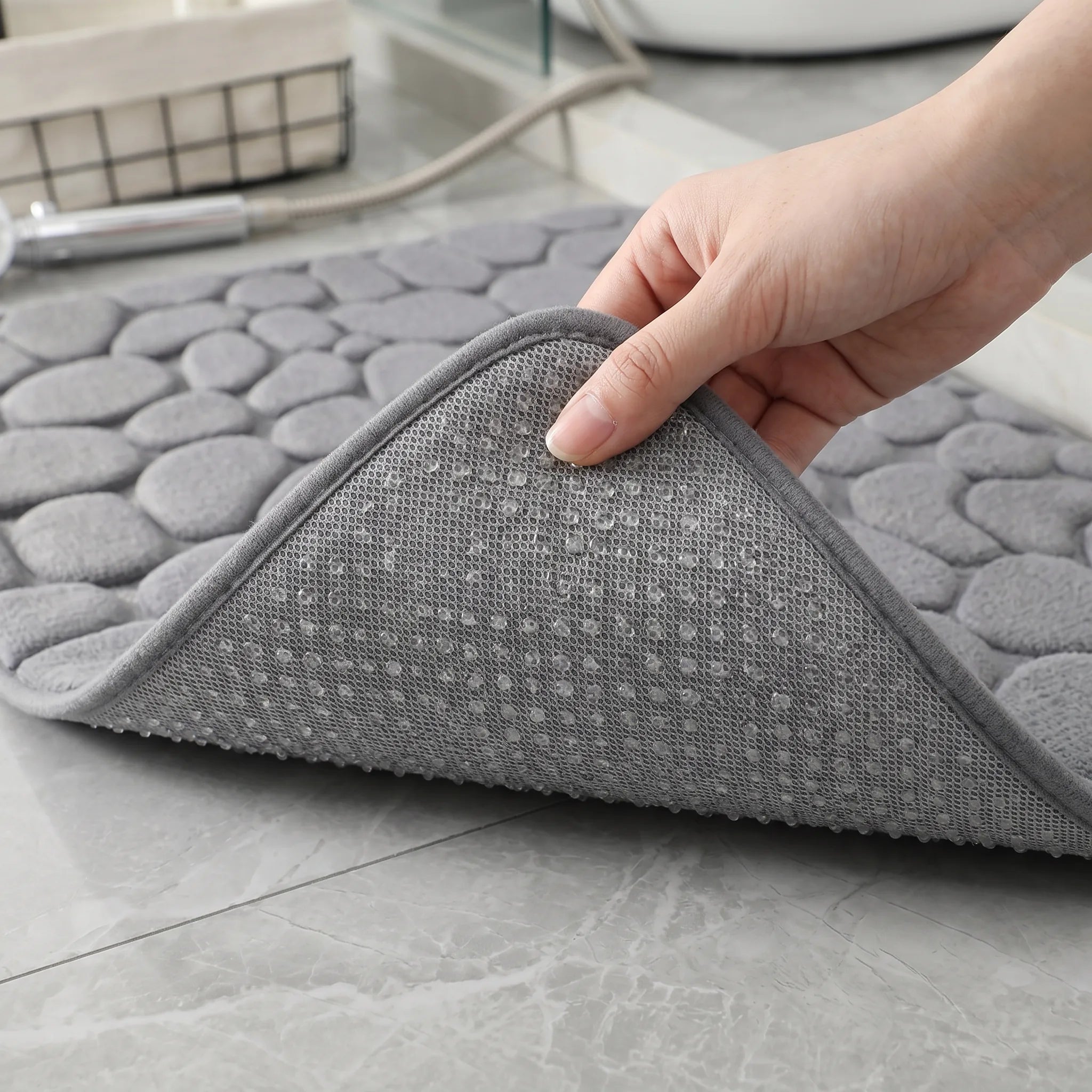 Dessous d'un tapis de bain antidérapant grande taille gris montrant les points d'accroche qui l'empêchent de glisser.