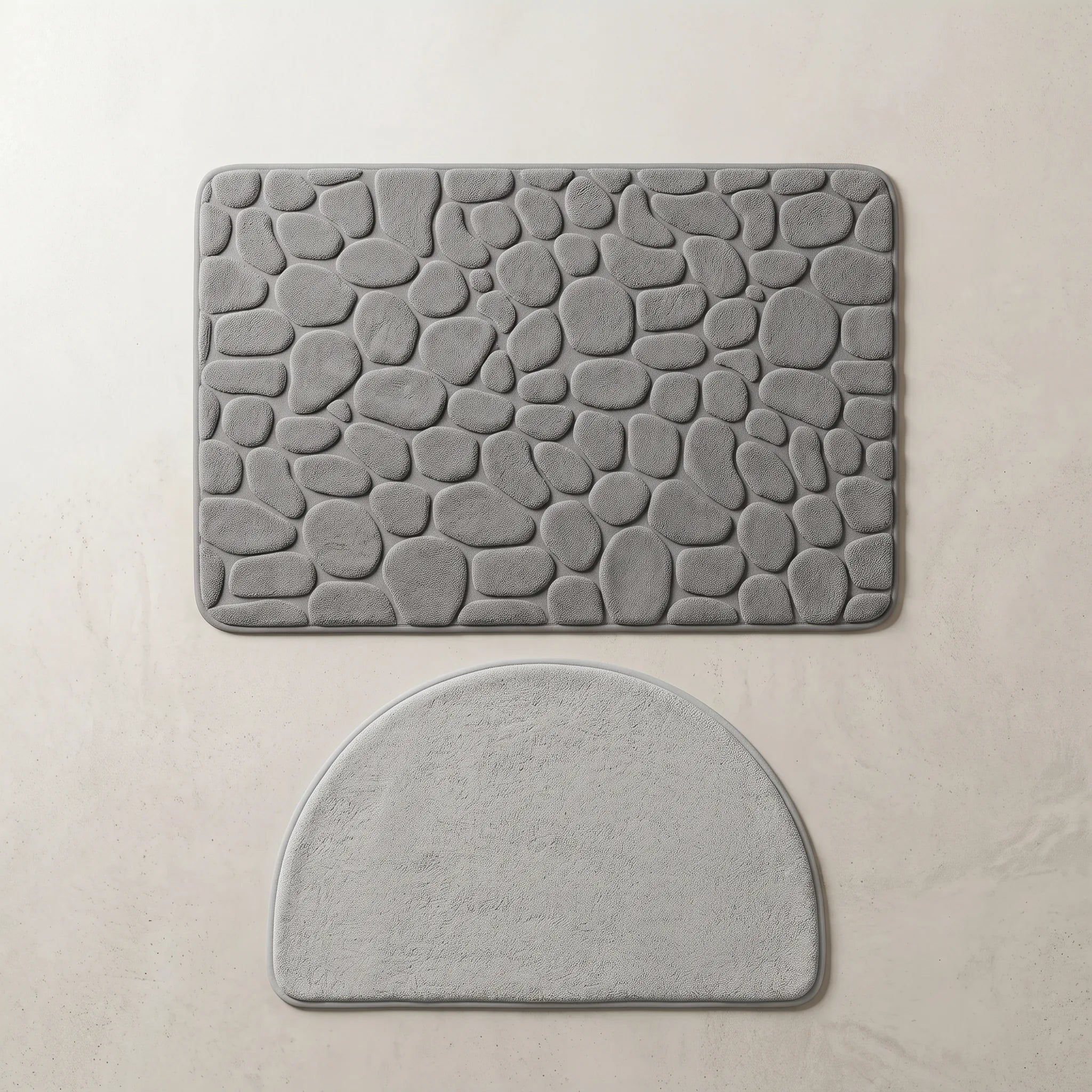 Vue de dessus du duo tapis de bain antidérapant grande taille gris et tapis demi-cercle gris clair, posés à plat côte à côte.